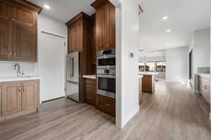 Kitchen featuring recessed lighting, appliances with stainless steel finishes, light wood-type flooring, and pendant lighting