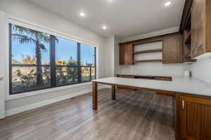 Unfurnished office with built in study area, light wood-type flooring, and recessed lighting