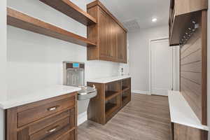 Kitchen featuring open shelves, light wood-type flooring, recessed lighting, and brown cabinetry