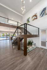 Staircase featuring wood finished floors, a chandelier, and recessed lighting