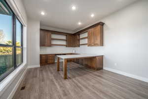 Kitchen featuring open shelves, recessed lighting, light countertops, light wood-style flooring, and brown cabinetry