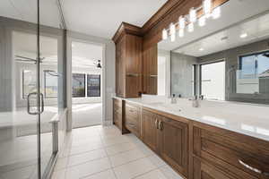 Bathroom featuring vanity, light tile patterned floors, and a stall shower
