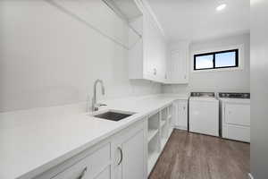 Laundry area with cabinet space, washing machine and clothes dryer, dark wood-style floors, and recessed lighting