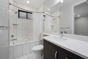 Full bathroom featuring tiled shower / bath, vanity, light tile patterned floors, and recessed lighting