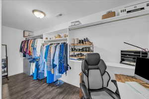 Walk in closet featuring dark wood-style floors
