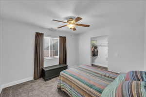 Bedroom with light carpet, a closet, a textured ceiling, and ceiling fan