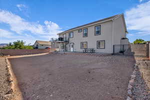 Rear view of property with a fenced backyard, stairs, stucco siding, and a patio area