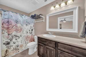 Bathroom with vanity, a shower with shower curtain, light tile patterned floors, and a ceiling fan
