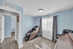 Sitting room with baseboards and wood finished floors