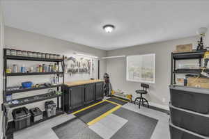Miscellaneous room with a textured ceiling and baseboards