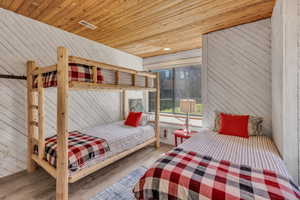 Bedroom featuring wood walls, wood ceiling, wood finished floors, and recessed lighting