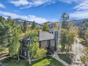 View of front of home with a mountain view and a front lawn