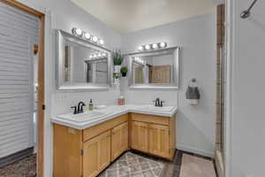 Full bath featuring double vanity, an enclosed shower, and dark wood finished floors