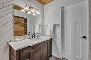 Bathroom with wood walls, vanity, and wood ceiling