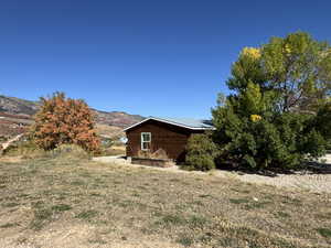 View of side of home featuring a mountain view and a lawn