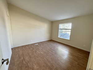 Bedroom with wood finished floors and baseboards