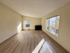 Living room with lofted ceiling and light wood-style flooring