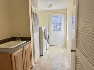 Laundry room with washing machine and clothes dryer and a heating unit