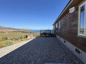View of yard with a deck with water view