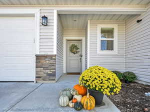 Doorway to property with a garage and stone siding