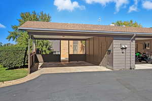 Back view of property showing carport, rear patio area and storage