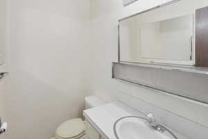 Half bath featuring vanity and toilet