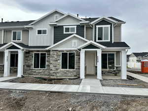Craftsman-style home with stone siding, board and batten siding, and roof with shingles