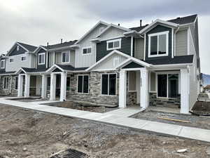 Craftsman-style house with stone siding, board and batten siding, and a residential view