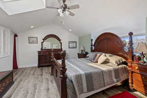 Bedroom featuring light wood-style floors, ceiling fan, and vaulted ceiling