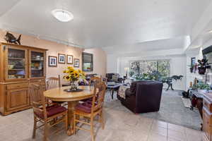 Dining room featuring light carpet, track lighting, a textured ceiling, and light tile patterned floors