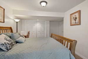 Carpeted bedroom featuring a closet and baseboards