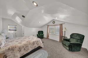 Carpeted bedroom featuring vaulted ceiling, a textured ceiling, and recessed lighting