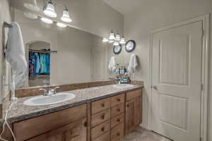 Bathroom featuring double vanity, light tile patterned floors, and a spacious closet