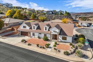 View of front of house with stone siding, driveway, a residential view, and stucco siding