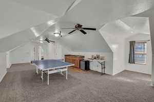 Recreation room with carpet flooring, lofted ceiling, and a ceiling fan