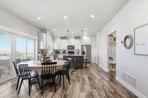 Dining space with light wood finished floors and recessed lighting