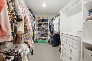 Walk in closet featuring light colored carpet