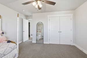 Carpeted bedroom featuring a closet and ceiling fan