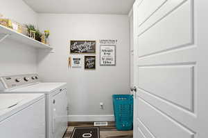 Washroom featuring dark wood-style floors and washing machine and dryer