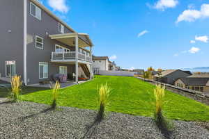 Fenced backyard featuring a patio, ceiling fan, and a residential view