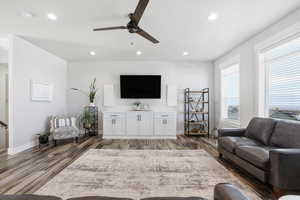 Living room with a ceiling fan, dark wood-style floors, and recessed lighting