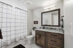 Full bathroom featuring a textured ceiling, vanity, light marble finish floors, and shower / tub combo with curtain