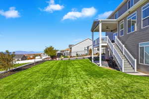 Fenced backyard featuring a ceiling fan, a residential view, a patio, and stairs