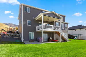 Back of house featuring a patio area, stairs, a yard, and a playground