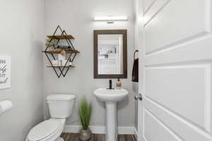 Half bath featuring wood finished floors