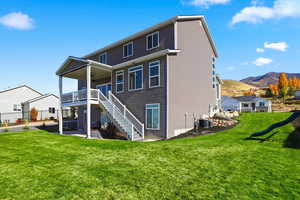 Rear view of property featuring a patio area, stairway, a deck with mountain view, and a ceiling fan