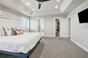 Bedroom featuring a raised ceiling, light carpet, ceiling fan, and recessed lighting