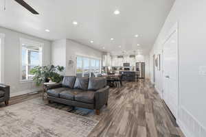 Living area with recessed lighting, healthy amount of natural light, dark wood-type flooring, and a ceiling fan