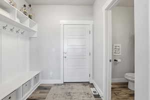 Mudroom featuring dark wood-type flooring and baseboards
