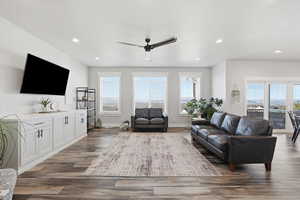 Living room featuring ceiling fan, recessed lighting, and dark wood-style flooring